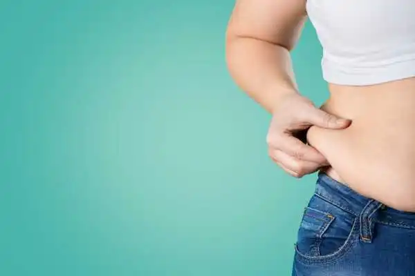 Image of woman pinching her love handles to show weight gain Maidenhead